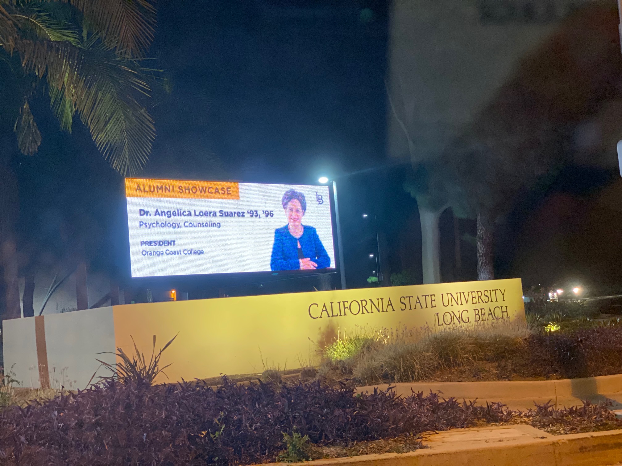A  billboard features a picture of and information about alumna Angelica Suarez